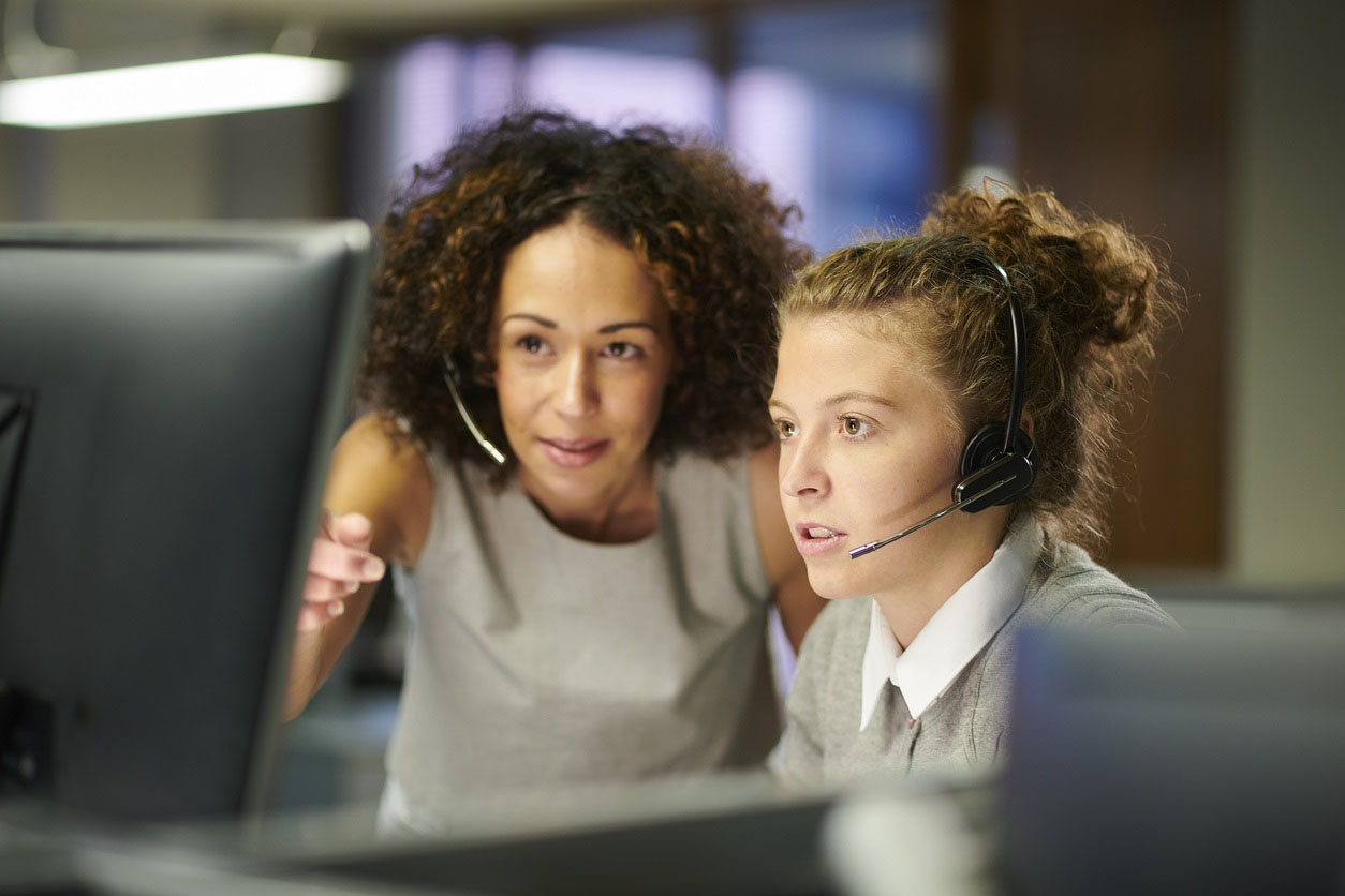 a female call centre worker helping female colleague