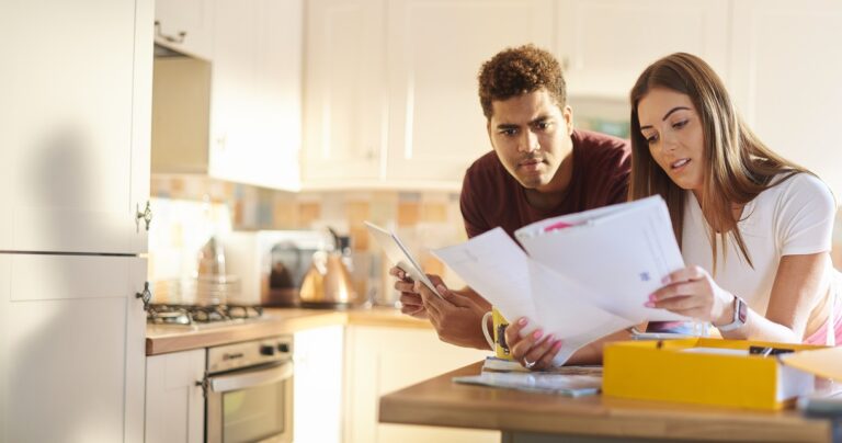 couple looking at paperwork in kitchen