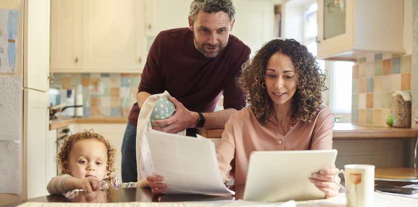 Family in kitchen looking at finance papers