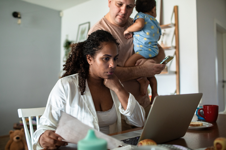 Close up of a Young family having breakfast and going over their bills and home finances on the laptop