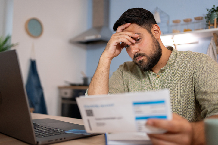 Worried man checking bills and looking at bills