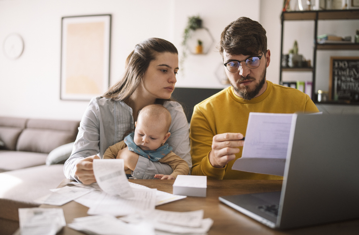 Young family with baby worried about family budget and high taxes and bills.